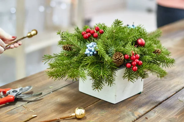 Κατασκευαστής του ντεκόρ Χριστουγέννων με τα χέρια τους. Χριστουγεννιάτικο κουτί με κλαδιά για τις διακοπές. Εορτασμό του νέου έτους. Άρχουσας τάξης στην πραγματοποίηση διακοσμητικά στολίδια — Φωτογραφία Αρχείου