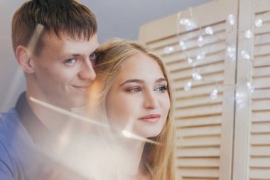 Güzel sevgi dolu çift pencereden dışarı bakarak. Adam ve kız birlikte sarılma. Sevgililer günü. Aynada yansıması. Nazik ve sevgi dolu bir çift