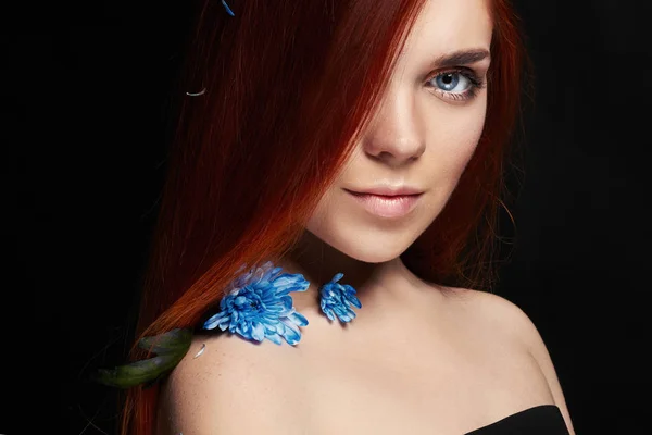 Сексуальная красивая рыжая девушка с длинными волосами. Портрет женщины на черном фоне. Шикарные волосы и глубокие глаза. Естественная красота, чистая кожа, уход за лицом и волосами. Сильные и густые волосы. Цветок — стоковое фото