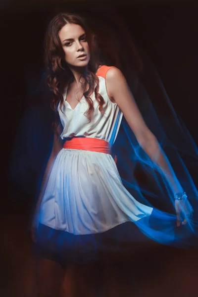 Blurred color art portrait of a girl on a dark background. Fashion woman with beautiful makeup and a light summer dress. Sensual tender image of a girl in motion. Studio portrait. — Stock Photo, Image