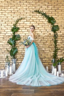 Gelin düğün beklentisiyle turkuaz güzel elbiseli. Dantel elbise deniz yeşil bir buket ile sarışın. Mutlu gelin, duygu, onun yüzünde sevinç. Güzel makyaj, Manikür ve saç modelleri kadınlar.