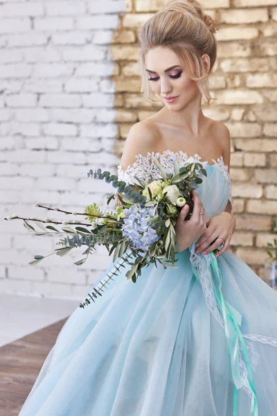 Невеста в красивом бирюзовом платье в преддверии свадьбы. Blonde in lace dress sea green with a bouquet. Счастливая невеста, эмоции, радость на его лице. Красивый макияж, маникюр и прически женщин . — стоковое фото