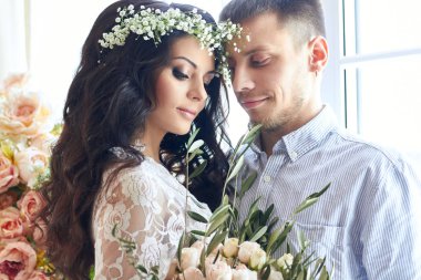 Gelin ve Damat Düğün için sabah hazır alıyorsanız. Seven çift evde sarılma. Yakışıklı damat ve büyüleyici gelin. Hazır düğün töreni çift almak