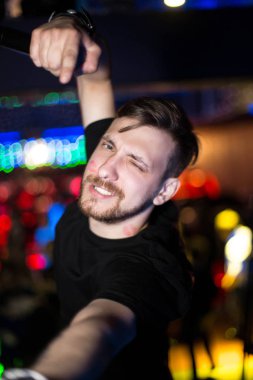 Karizmatik başrol kamera için poz bir gece kulübü. Adam elinde mikrofon ile.