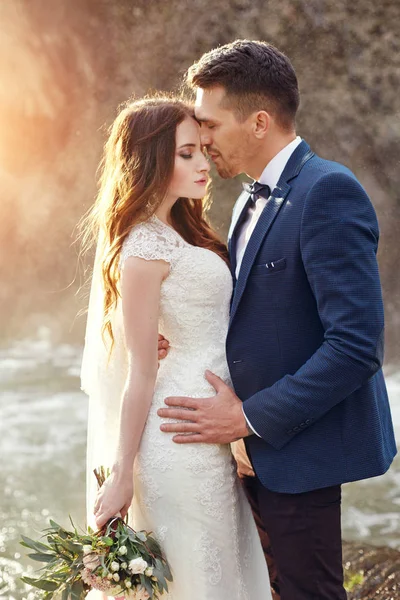 Bir kaç gün batımında, aşık Çift'nde Günbatımı öpüşme sarılma. Düğün töreni açık havada. Güzel gelin ve damat ile buket çiçek. Beyaz gelinlik gelin için. Düğün çift sarılmak seviyorum. Bulanık.