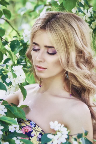 Outdoor moda bella giovane donna circondata da fiori lilla estate. Cespuglio di lilla di fiore di primavera. Ritratto di una ragazza bionde . — Foto Stock