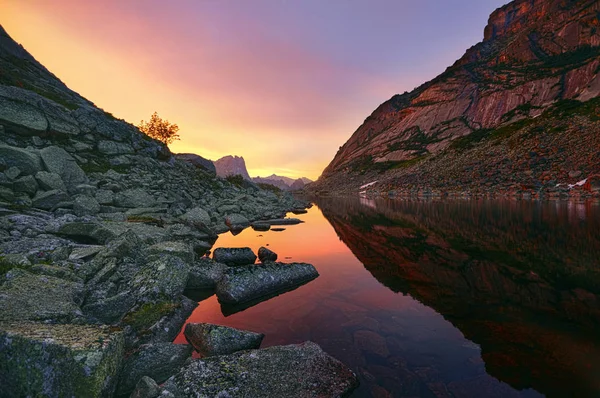Захід сонця у горах біля озера. Сонячне світло відбивається на вершинах гір. Золотий світло з неба знайшло своє відображення у гірському озері. Ergaki — стокове фото