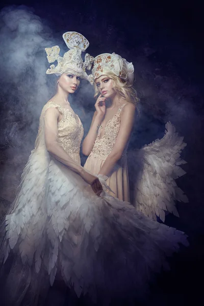 Angyal nimfa tündér art képek a nők. Lányok angel Wings, szépség modellek pózol a sötét háttér előtt. Mese mágia mágikus lány gyönyörű a drága ruhák. — Stock Fotó