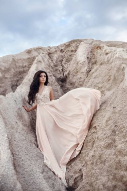 Arka planda dağlar ile Rüzgar bekleyen bir ışık mavi elbise kız. Temiz ve kusursuz güzellik, kadınlar masal bir görüntüsünü.