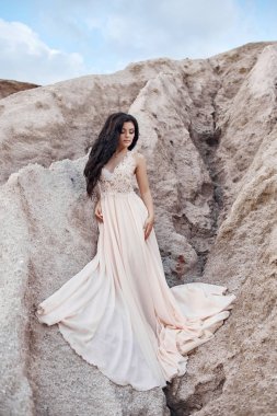 Arka planda dağlar ile Rüzgar bekleyen bir ışık mavi elbise kız. Temiz ve kusursuz güzellik, kadınlar masal bir görüntüsünü.