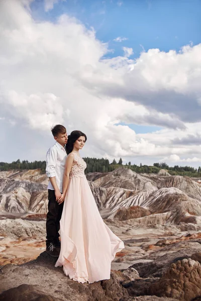 La pareja cariñosa se abraza en el fondo de las montañas rojas. Ama y cuida el uno del otro. Pareja cariñosa esperando la boda . —  Fotos de Stock