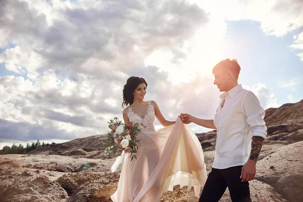 Casal amoroso abraça no fundo das montanhas vermelhas. Amar e cuidar um do outro. Casal amoroso à espera do casamento . — Fotografia de Stock