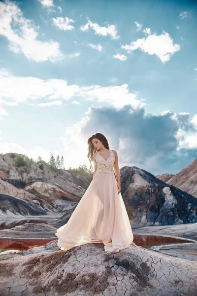Дівчина в світло-блакитній сукні, що стоїть на вітрі з горами на задньому плані. Чиста і бездоганна краса, казковий образ жінки . — стокове фото