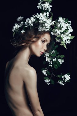 Sanat güzellik siyah arka plan üzerinde çıplak kadın portresi. Bir kadının vücudunda yeni gelişen bir elma ağacı dalı. Bahar geldi.