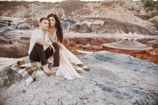 Belo casal apaixonado beijando e abraçando sentado na rocha — Fotografia de Stock