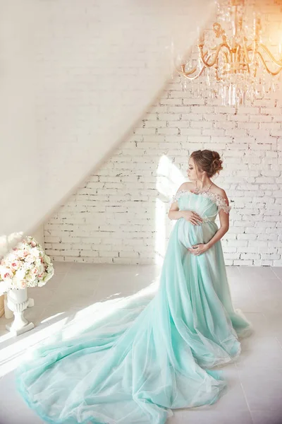 Mulher grávida em um lindo vestido de azul marinho. Em antecipação ao nascimento de uma criança, além da família. Gentil e amorosa mãe — Fotografia de Stock