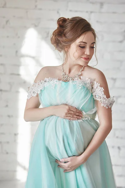Ευτυχισμένος έγκυος γυναίκα στο Μακρύ βραδινό φόρεμα, αγγίζοντας τα χέρια της κοιλιάς. Περιμένοντας τη γέννηση ενός παιδιού, μια γυναίκα με τον όγδοο μήνα της εγκυμοσύνης. Πολυτελές έγκυος κορίτσι σε ένα φόρεμα από μπλε χρώμα. — Φωτογραφία Αρχείου