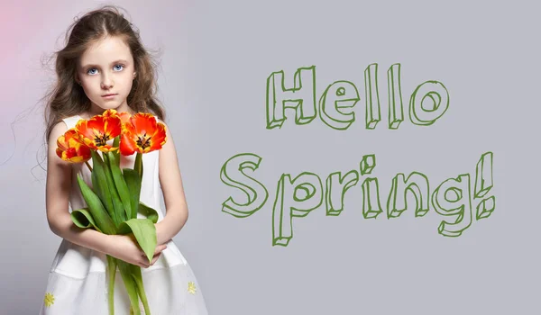 Hallo Frühling, 8. März. Mode rothaarige Mädchen mit Tulpen in den Händen. Studioaufnahme auf hellem Hintergrund. Frühlingstag, Geburtstag, Urlaub, Muttertag, erster Schultag. — Stockfoto