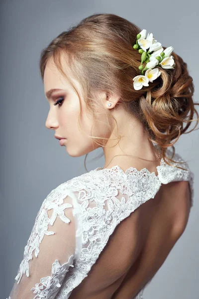 Joven novia en un lujoso vestido de novia blanco y hermoso cabello. Mujer antes de la ceremonia de la boda, una figura perfecta de la novia, hermoso maquillaje y peinado . — Foto de Stock