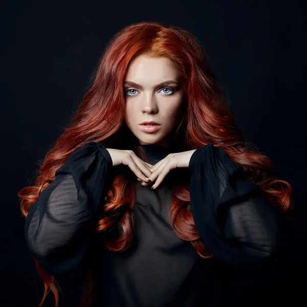 Mulher bonita com cabelo vermelho em um fundo preto. Retrato de — Fotografia de Stock