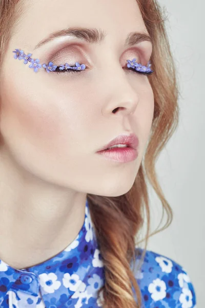 Woman with pigtails and blue flowers on the eyelashes, skin care — Stock Photo, Image