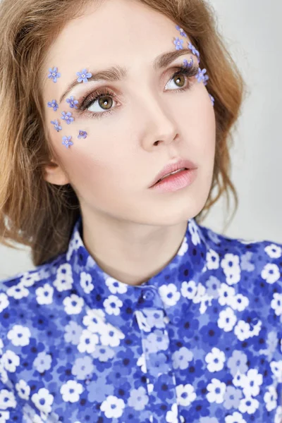Woman face with blue flowers, the girl in the flower dress blue.