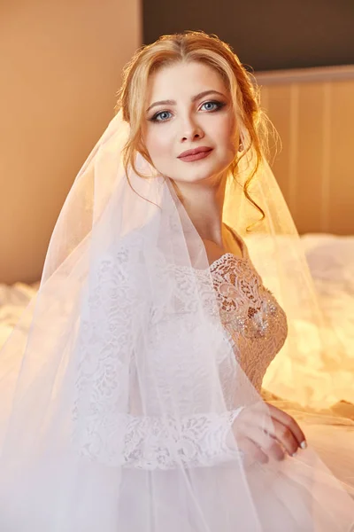 Retrato de una novia sentada en un elegante vestido de novia blanco en el — Foto de Stock