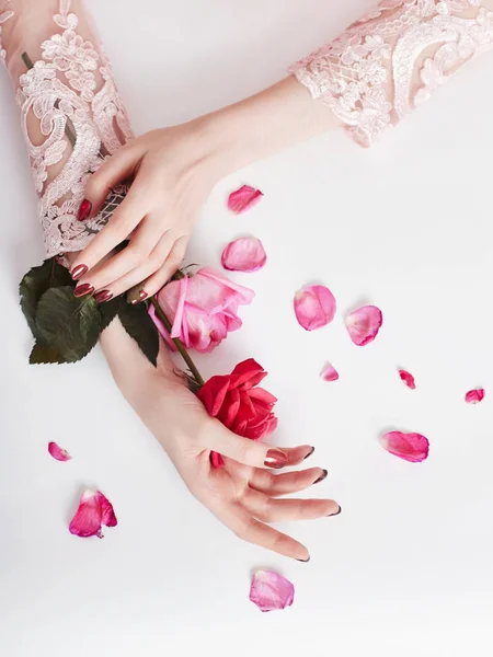 Mode konst stående kvinna i sommarklänning och blommor i sin hand med en ljusa kontrasterande makeup. Kreativa skönhet foto flickor sitter vid bordet på en kontrasterande rosa bakgrund med färgade skuggor. — Stockfoto