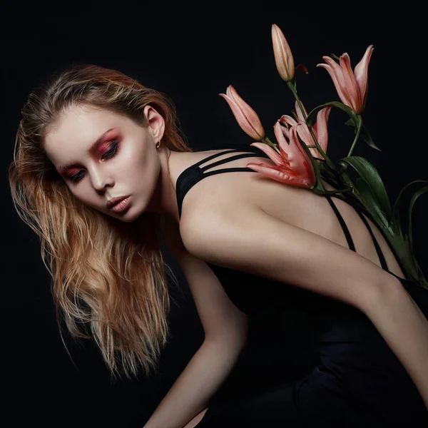 Art beauty girl with lilies behind on a black background. Creati