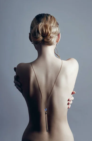 Art Nude fashion Nude back of blonde woman on grey background. G