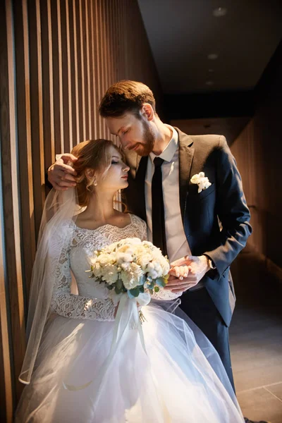 Bride and groom hugging and kissing while standing on the stairs