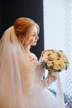 Beyaz gelinlik ve uzun duvak sarışın gelin bekliyor