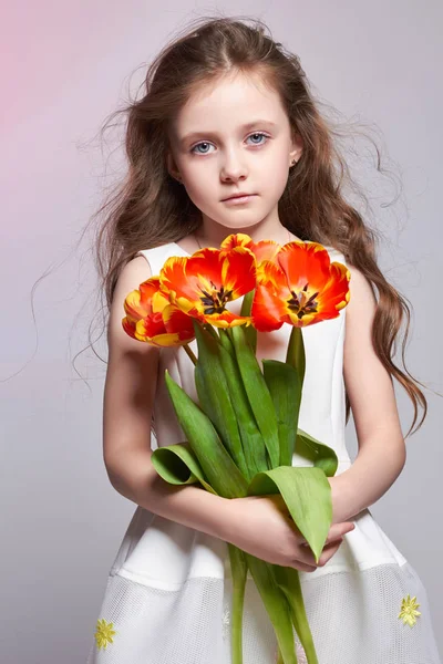 Girl with big blue anime eyes and a bouquet of Tulip flowers in