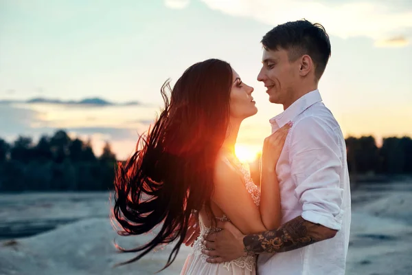 Amor beso y abrazos en parejas de amor al atardecer en el sol de la noche, un paseo por las montañas y colinas. Sensual y gentil mirada de chica amorosa, los rayos del sol brillan en la pareja amorosa . —  Fotos de Stock