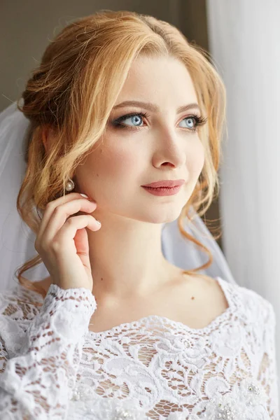 Hermosa novia rubia en la mañana en un vestido de novia blanco w — Foto de Stock