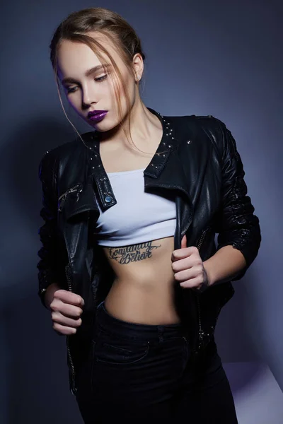 Sexy blonde Fille avec tatouage en veste et jeans en cuir, portra — Photo