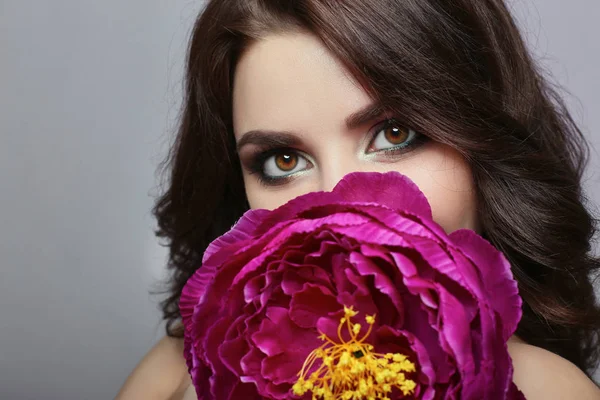 Beautiful girl with dark hair and big flower near face. Large pu — Stock Photo, Image
