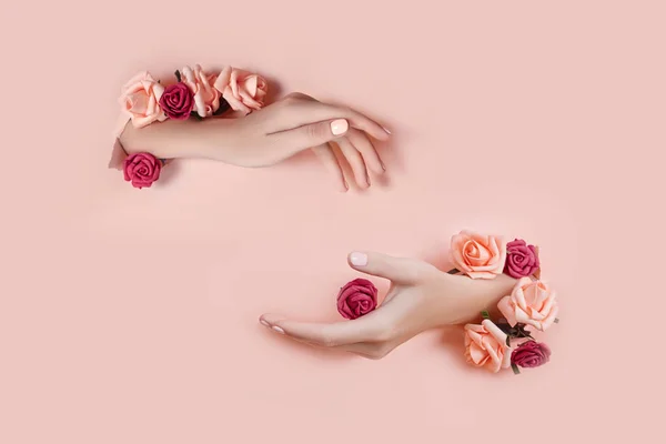 Conjunto de manos con flores artificiales que sobresalen del agujero pape rosa —  Fotos de Stock