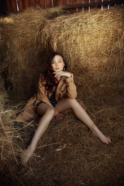 一个女孩躺在靠近干草的村子里，一个女人的画像 — 图库照片