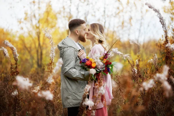 Pareja enamorada pasea por el bosque de otoño. Abrazos y besos de m — Foto de Stock