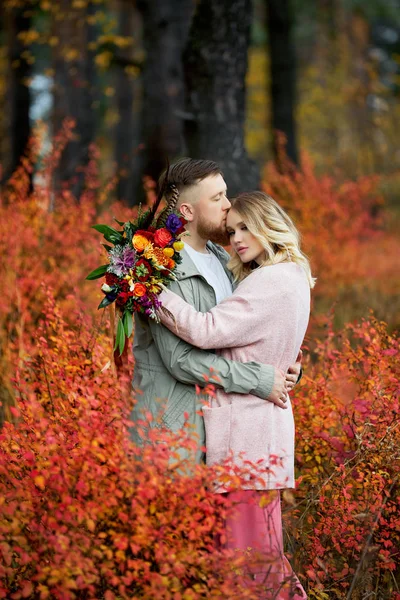 Verliefd stel wandelt door het herfstbos. Knuffels en kussen van m — Stockfoto