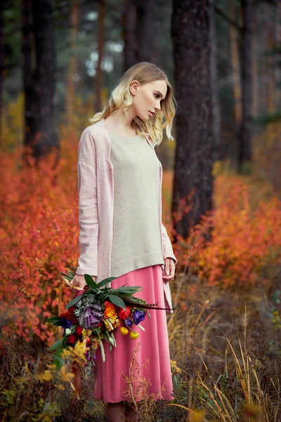 Chica caminando en el bosque de otoño. Un hermoso ramo grande de — Foto de Stock