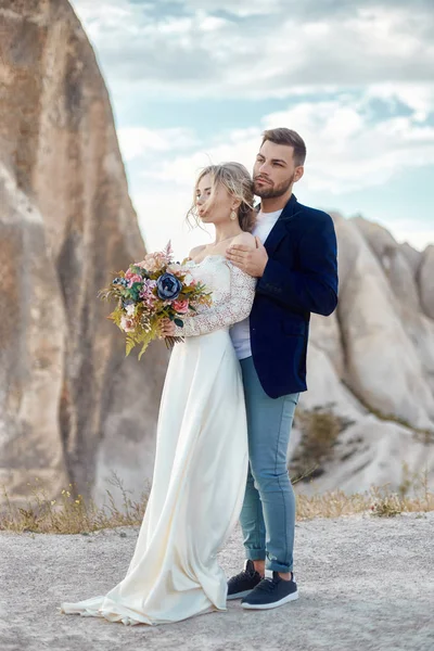 Couple in love hugs and kisses in fabulous mountains in nature.