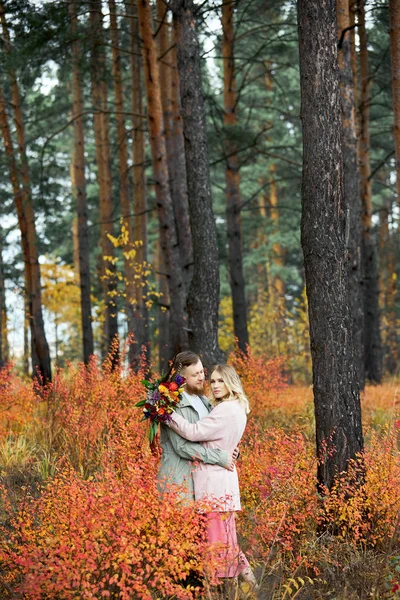 Couple in love walks through autumn forest. Hugs and kisses of m