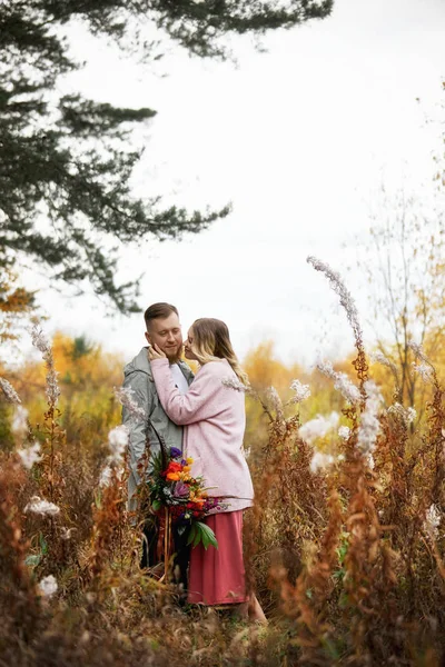 Pareja enamorada pasea por el bosque de otoño. Abrazos y besos de m —  Fotos de Stock