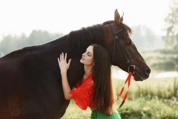 Gypsy girl rides a horse in a field in the summer. A woman with — ストック写真