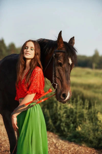 Zigeunermeisje rijdt in de zomer op een paard in een veld. Een vrouw met — Stockfoto