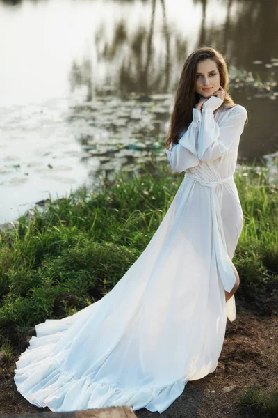 Sabahları uzun beyaz elbiseli güzel, ince bir kadın yürüyor. — Stok fotoğraf