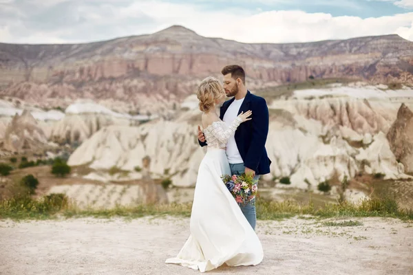 Birbirlerine aşık çiftler doğadaki muhteşem dağlarda sarılıp öpüşürler.. — Stok fotoğraf