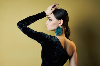 Siyah, şık bir gece elbisesi giymiş, açık tenli esmer kız.